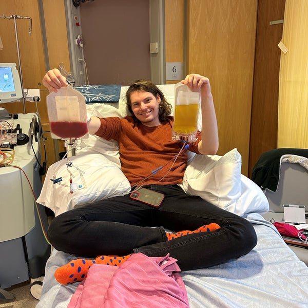 Young man smiling on a hospital bed and holding bags of stem cells Young man smiling on a hospital bed and holding bags of stem cells