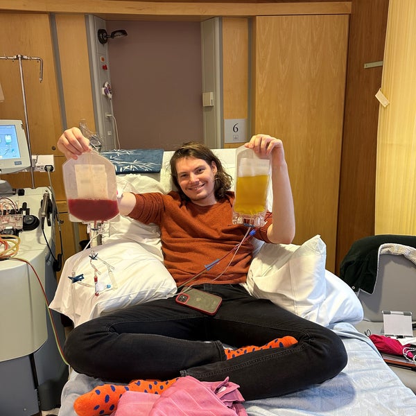 Young man smiling on a hospital bed and holding bags of stem cells Young man smiling on a hospital bed and holding bags of stem cells