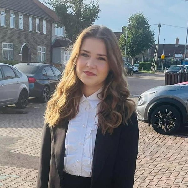 Amber dressed in black suit standing in a car park Amber dressed in black suit standing in a car park