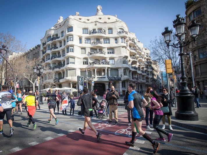 Runners in race in Barcelona, passing by Casa Mila Runners in race in Barcelona, passing by Casa Mila