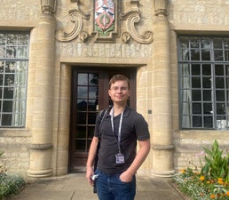 Zac standing in front of St Ann's College, Oxford