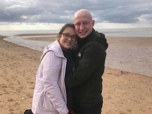 Ben and Amy smiling together on the beach