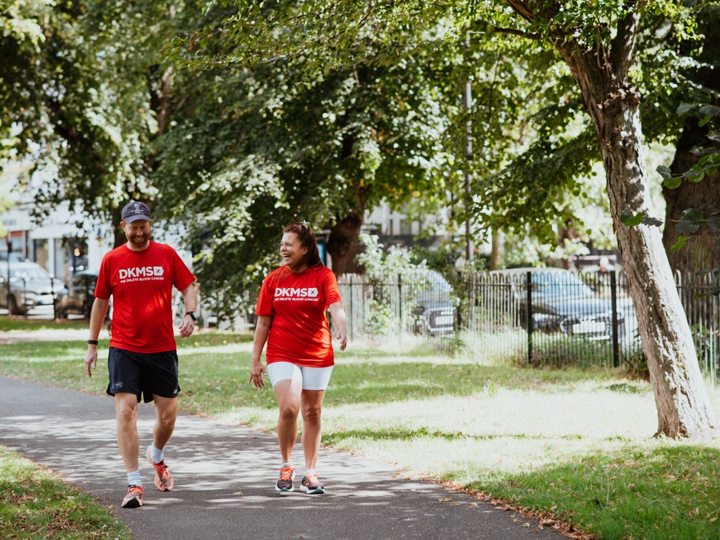 Two people in DKMS t-shirts walking in the park Two people in DKMS t-shirts walking in the park