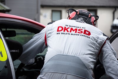 Detail of the back of David Edwards racing suit showing DKMS logo and 'We delete blood cancer' strapline