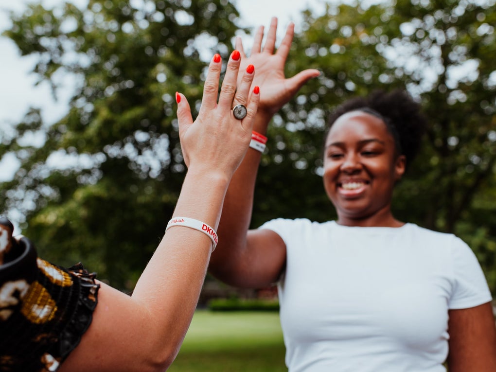 Two young women giving a high five in the park Two young women giving a high five in the park