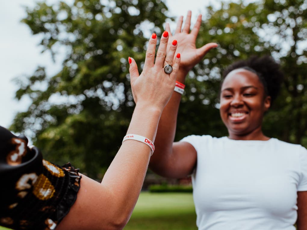 Two young women giving a high five in the park Two young women giving a high five in the park