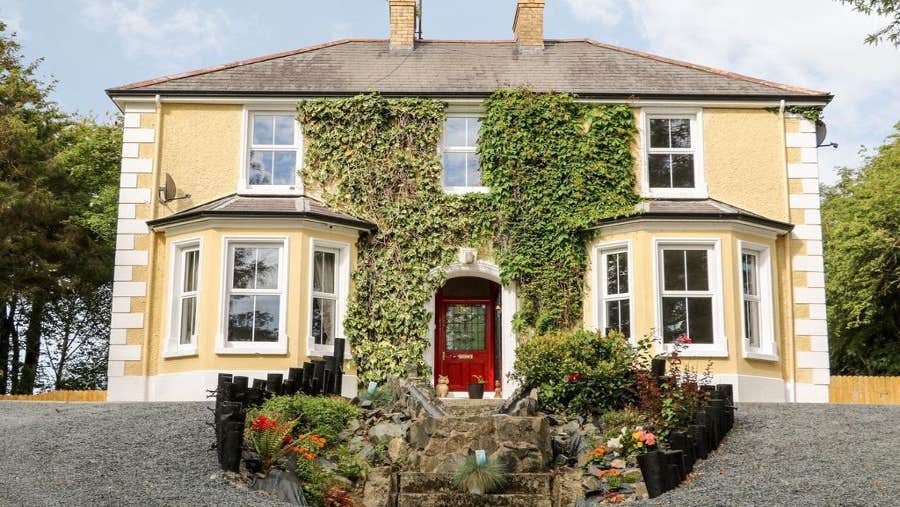 Front view of yellow house with red door
