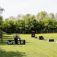 An activity course for dogs with wooden structures on a green field