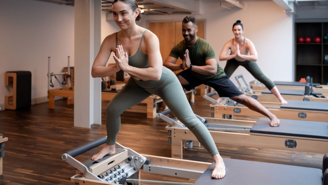 Three people balancing on a table while in a yoga pose
