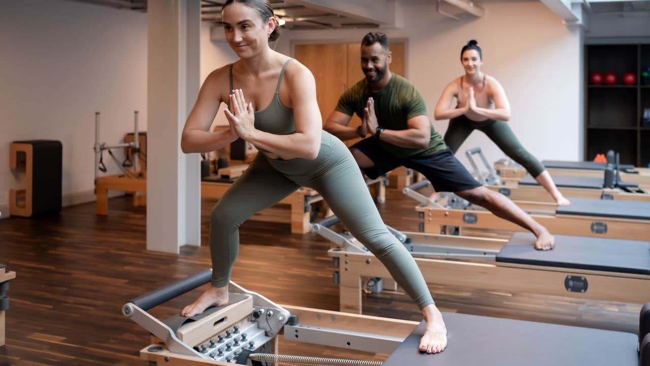 Three people balancing on a table while in a yoga pose