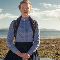 3 women standing apart on a beach with sea in background.