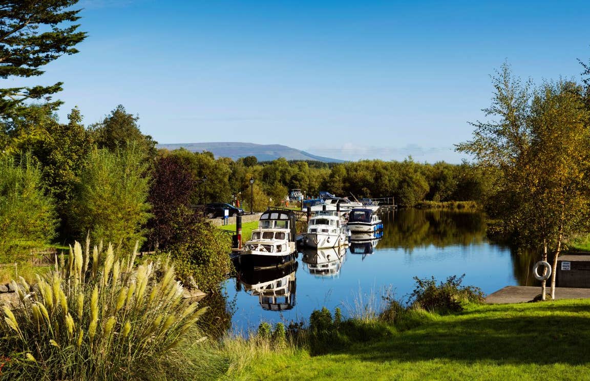 Cruisers moored at Leitrim Village in County Leitrim on a sunny day near some trees
