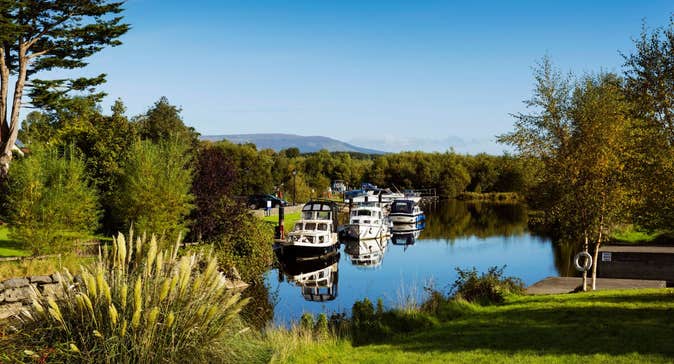 Cruisers moored at Leitrim Village in County Leitrim on a sunny day near some trees