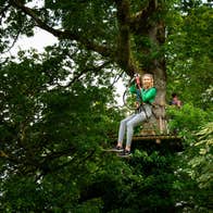 Girl in a green jumping sliding down a zipline in Roscommon