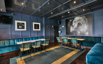 A subdued coloured room with comfortable seating and tables