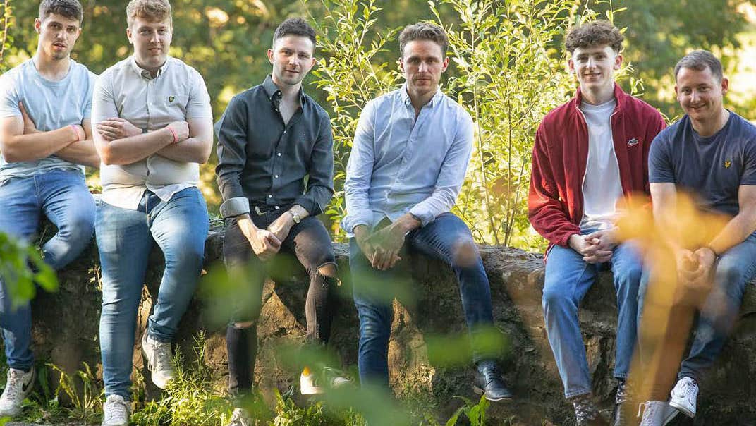 The Tumbling Paddies seated on a low wall