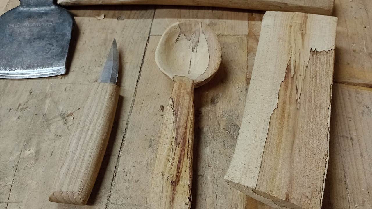 Four hand carved tools laid out on a table