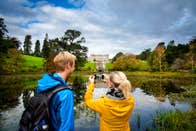 Two people taking a picture of Powerscourt House and Gardens in County Wicklow