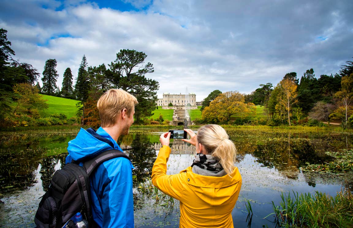 Two people taking a picture of Powerscourt House and Gardens in County Wicklow