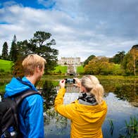 Two people taking a picture of Powerscourt House and Gardens in County Wicklow