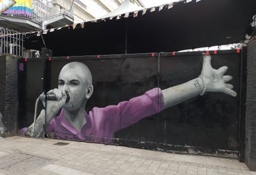 Mural of a singer wearing a pink shirt holding a microphone