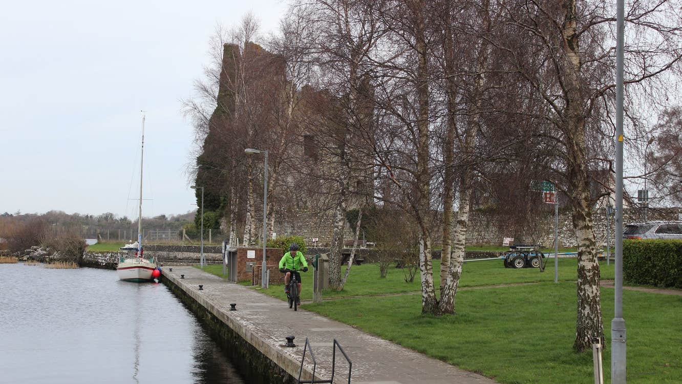 A cyclist on a pier by a lake