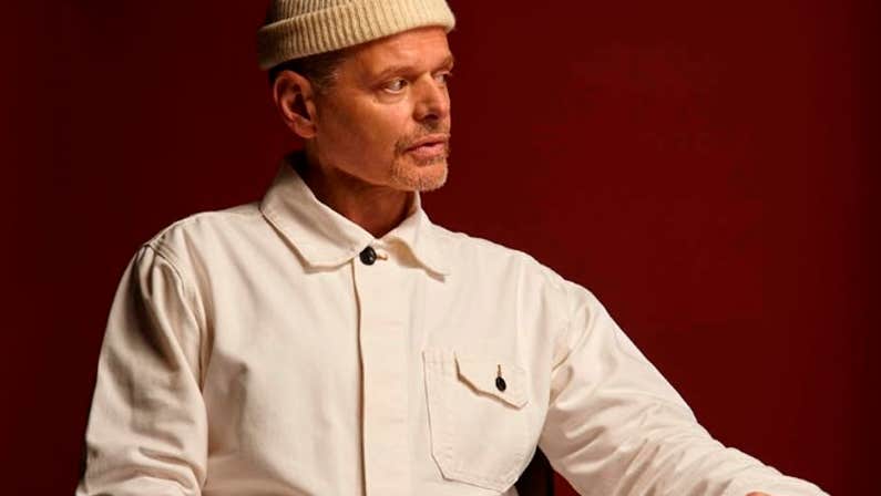 A man seated at a table looking away to his left