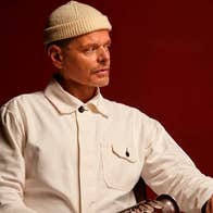 A man seated at a table looking away to his left
