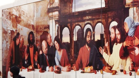 Street art image based on the last supper with people sitting on one side of a dinner table