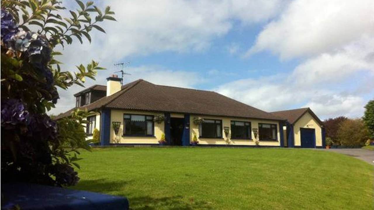 Exterior view of house set on a large lawn.