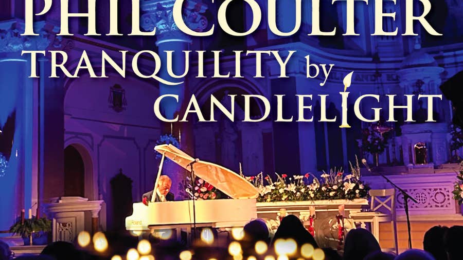 Phil Coulter - Tranquillity By Candlelight, a man seated at a pale grand piano with blurry lit candles in the foreground