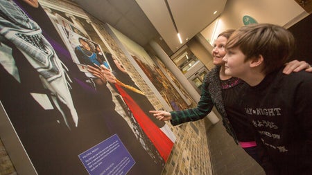 A mother and son looking at a display in a museum