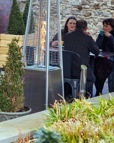 Image of people sitting in a coffee shop looking out onto a garden