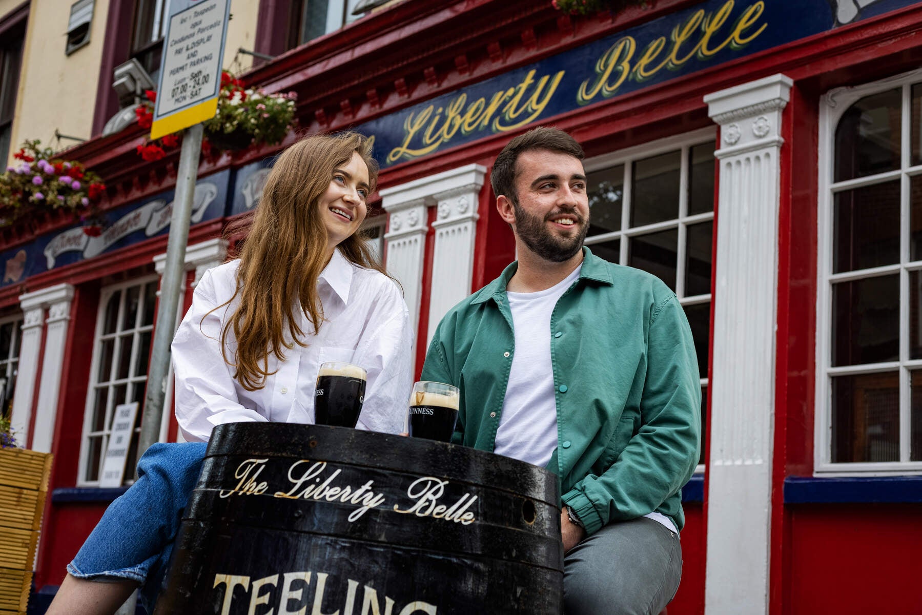 Two people drinking pints of Guinness outside the Liberty Belle pub in Dublin 8.