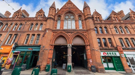 Victorian red brick market building with arched entrances decorative stonework and Gothic style architectural details
