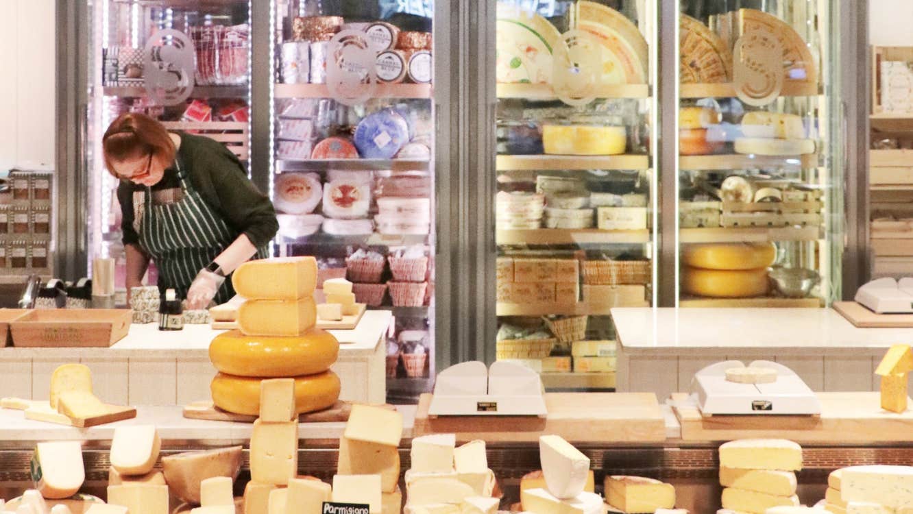 An extensive display of different cheeses in a retail shop setting