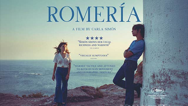 Film poster with 2 people standing on rocky area with sea in the background.