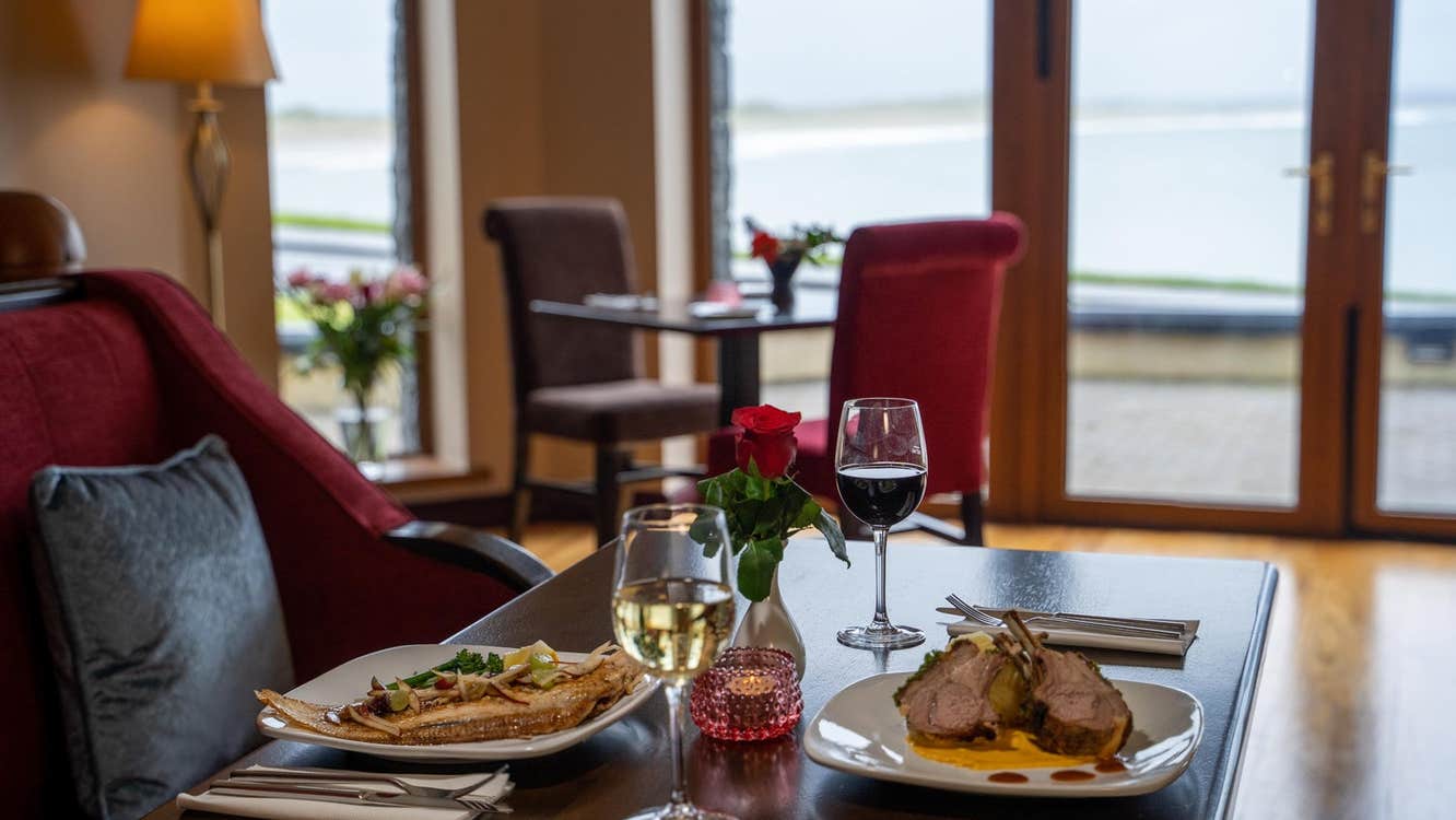 A table set for two people with a view of the ocean