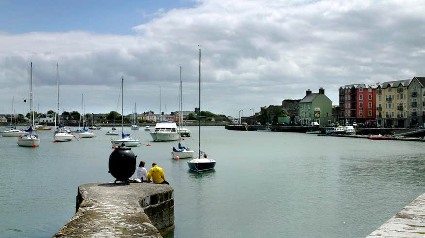 Two people sitting at Dungarvan Harbour in County Waterford.