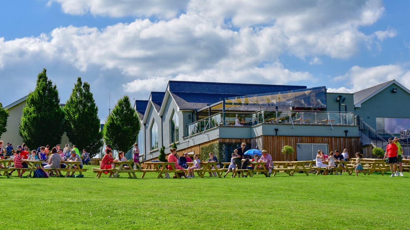 A large group of people sitting at picnic benches