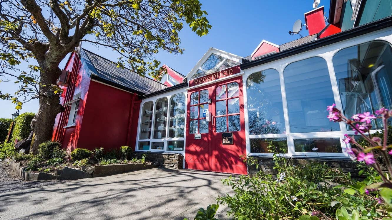 The front of a building with large windows and a red front door