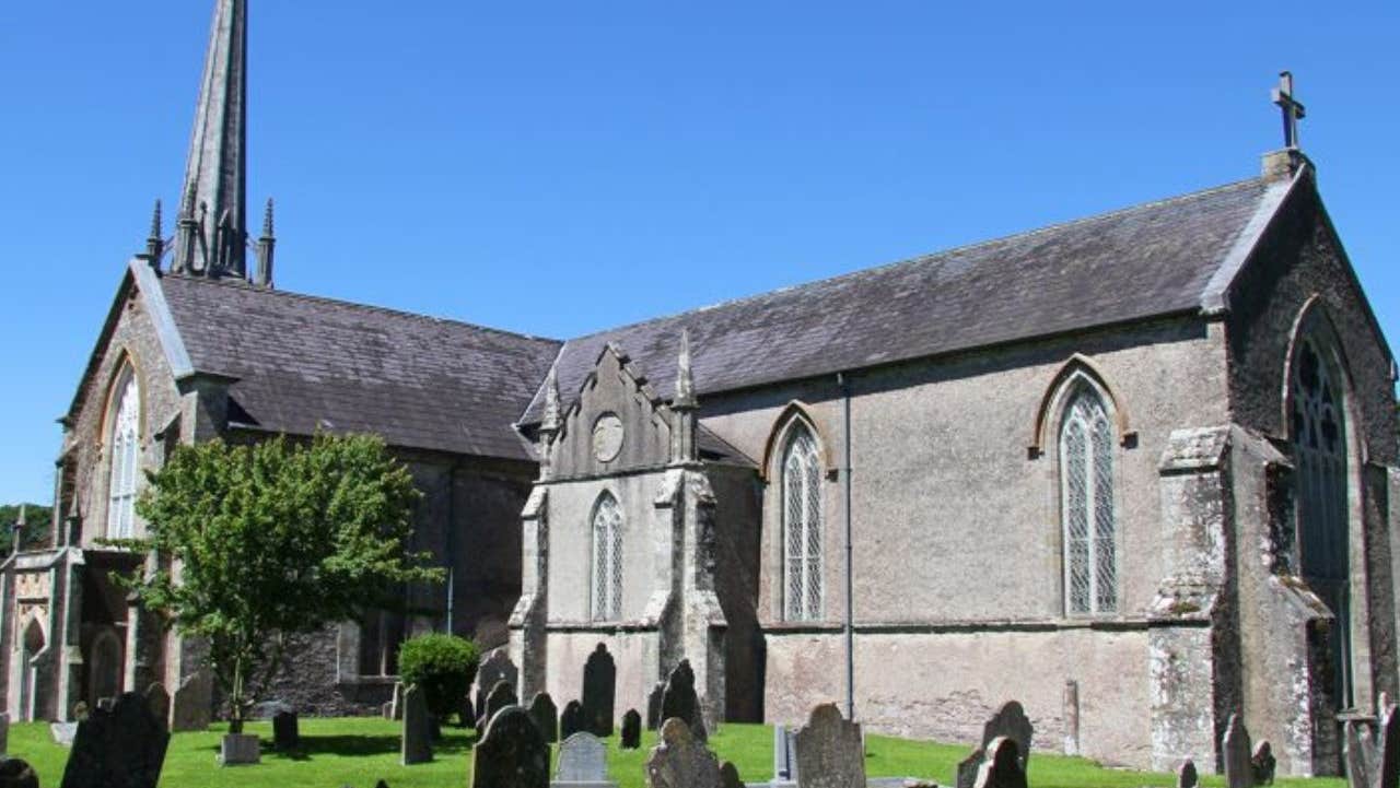 A large church with a cemetery and lots of headstones