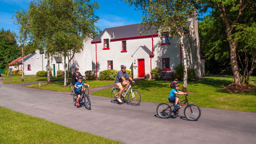 Family cycling outside the cottages