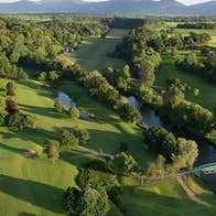 Aerial view of Cahir Park Golf Club green with lots of trees and mountains in the distance