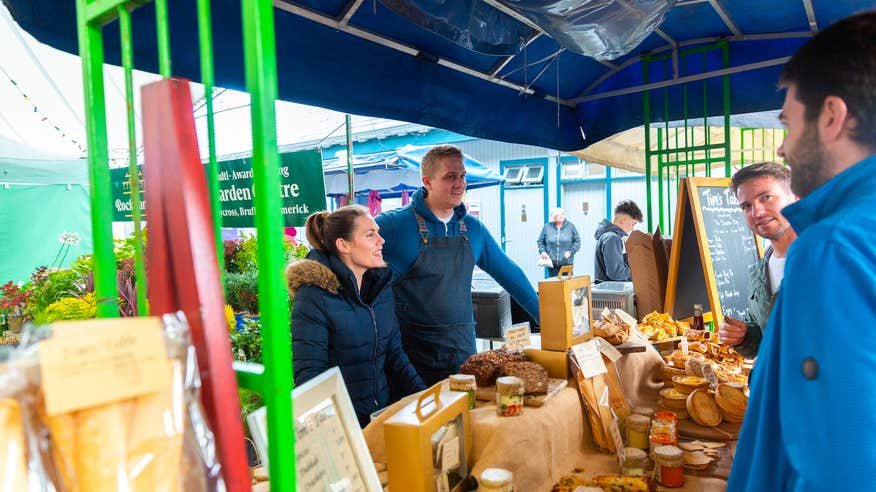 Two merchants serving customers at the Milk Market in Limerick.