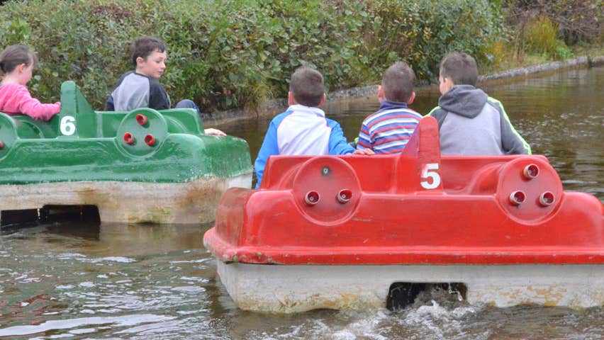 Four children on two small boats on a lake at Ionad Cois Locha at Dunlewey in County Donegal