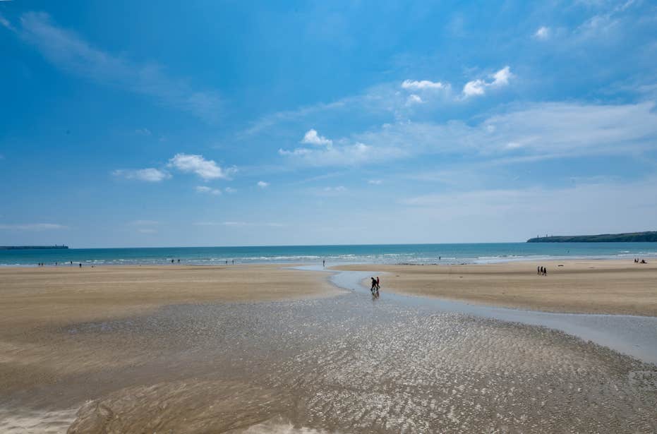 People walking on Tramore Beach in County Waterford.