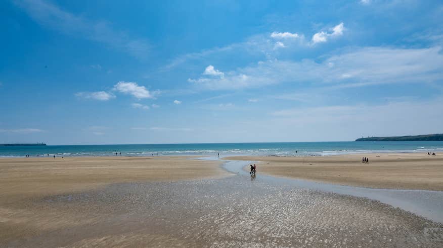 People walking on Tramore Beach in County Waterford.