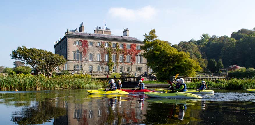 People kayaking past Westport House and Gardens in County Mayo