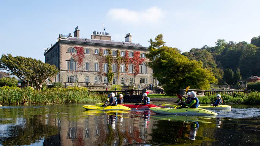 People kayaking past Westport House and Gardens in County Mayo